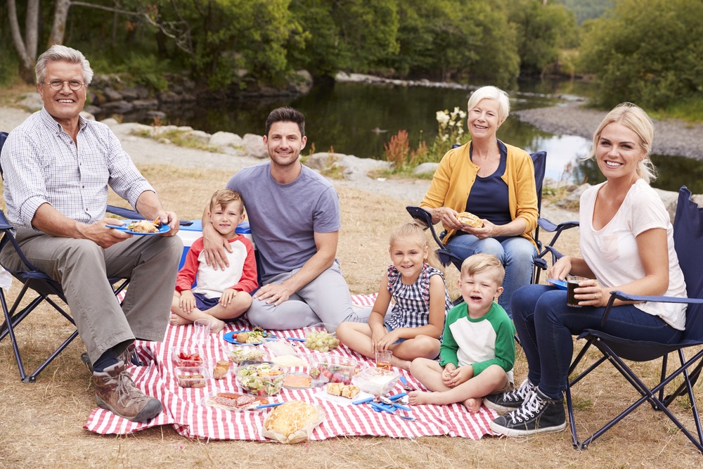 Portrait Of Multi Generation Family Enjoying Picnic In Countryside