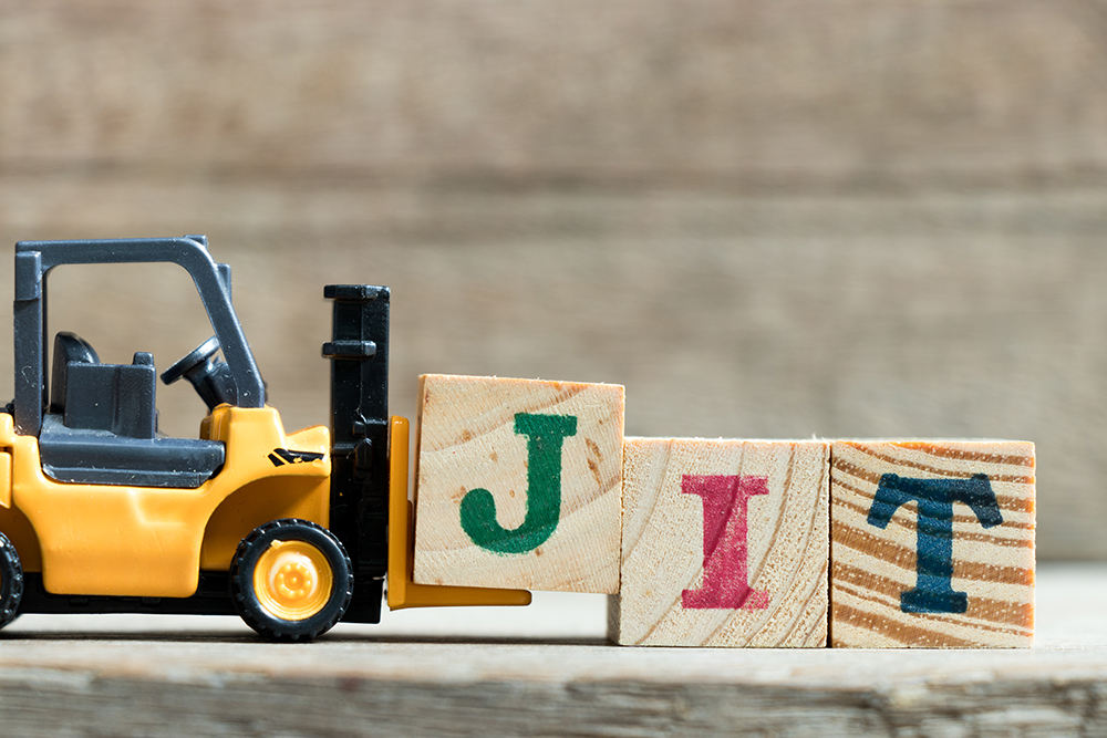 Toy yellow forklift hold letter block J to complete word JIT (Abbreviation of Just in time)on wood background