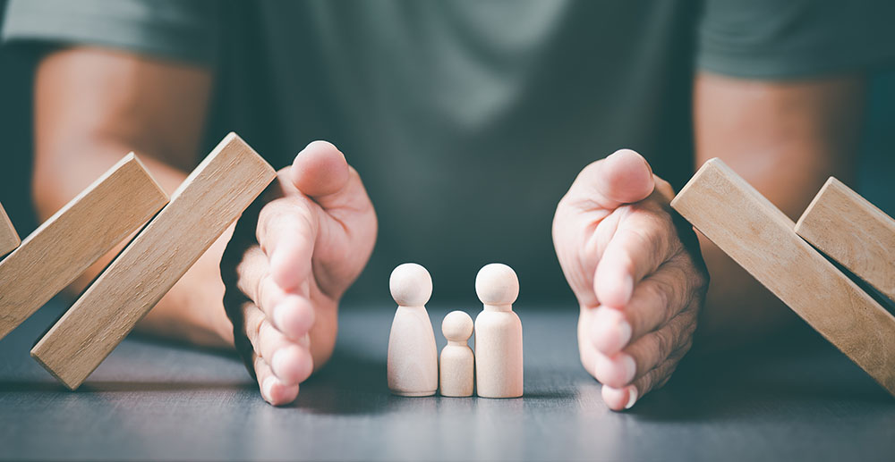 The young man used both of his hands to protect from the falling wooden blocks.,The concept of caring, protecting, protecting family members to be safe and happy.