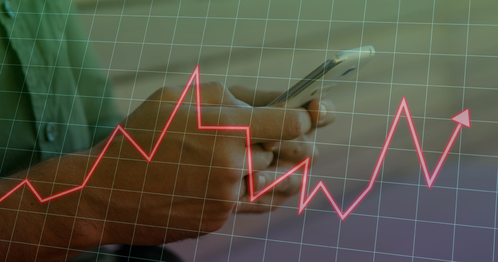 Image of arrow graph on grid pattern over midsection of caucasian man typing on cellphone. Digital composite, multiple exposure, report, business, three dimensional and technology concept.