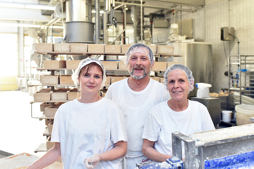 Worker in a large bakery - industrial production of bakery products on an assembly line 