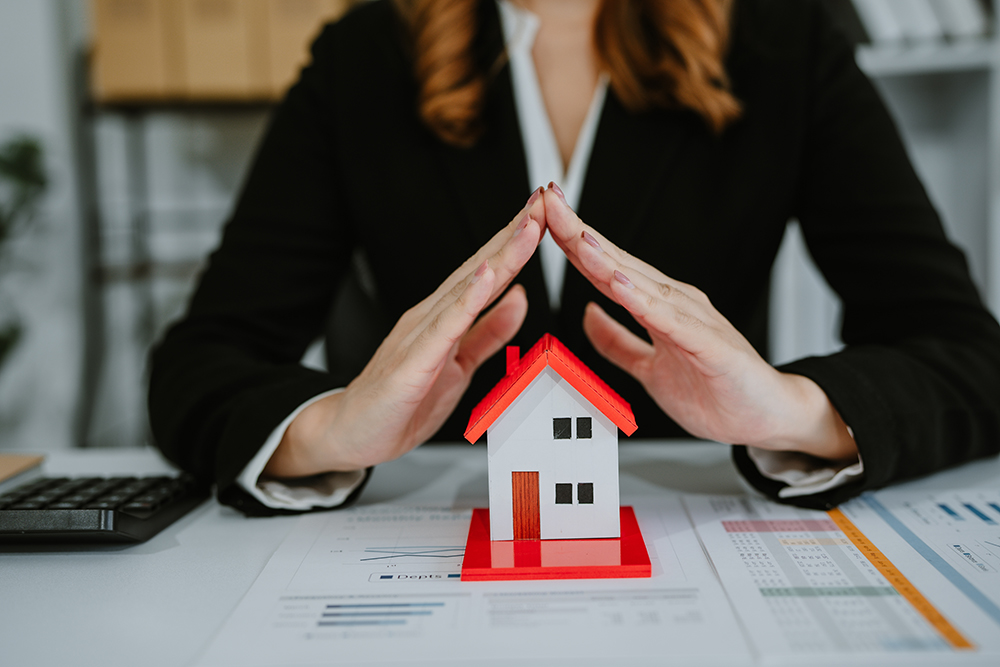 Young Asian woman in office, architecture, building, construction, real estate and property concept - close up of mobile phone, house model