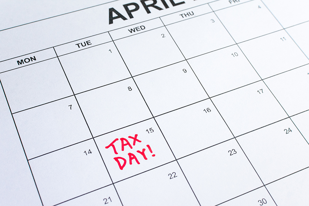 Calendar of April with “Tax Day!” reminder on the 15th. Deadline for filing Individual Income Tax Return and Corporate Tax Return. Taxation, tax season, reminder, planning, regulatory filing concept