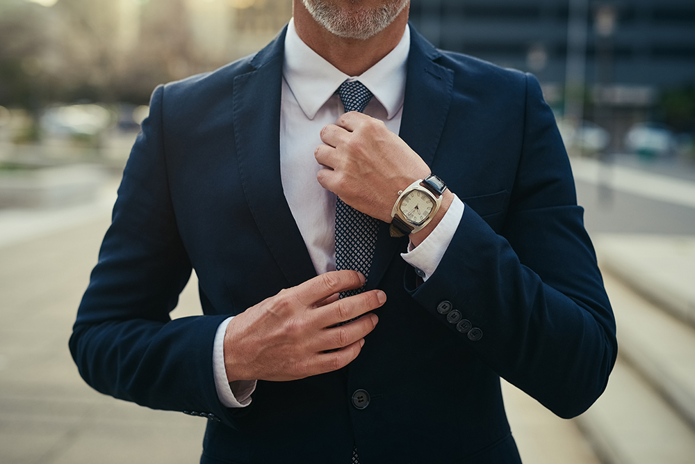 Hands, businessman and adjust tie in city to prepare for travel, commute and corporate job opportunity outdoor. Professional, manager and fix necktie on suit in street for fashion of mature salesman