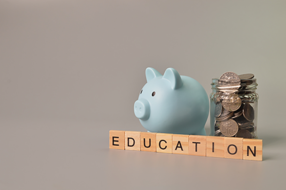 Stack of coins, piggy bank and alphabet letters with text EDUCATION.