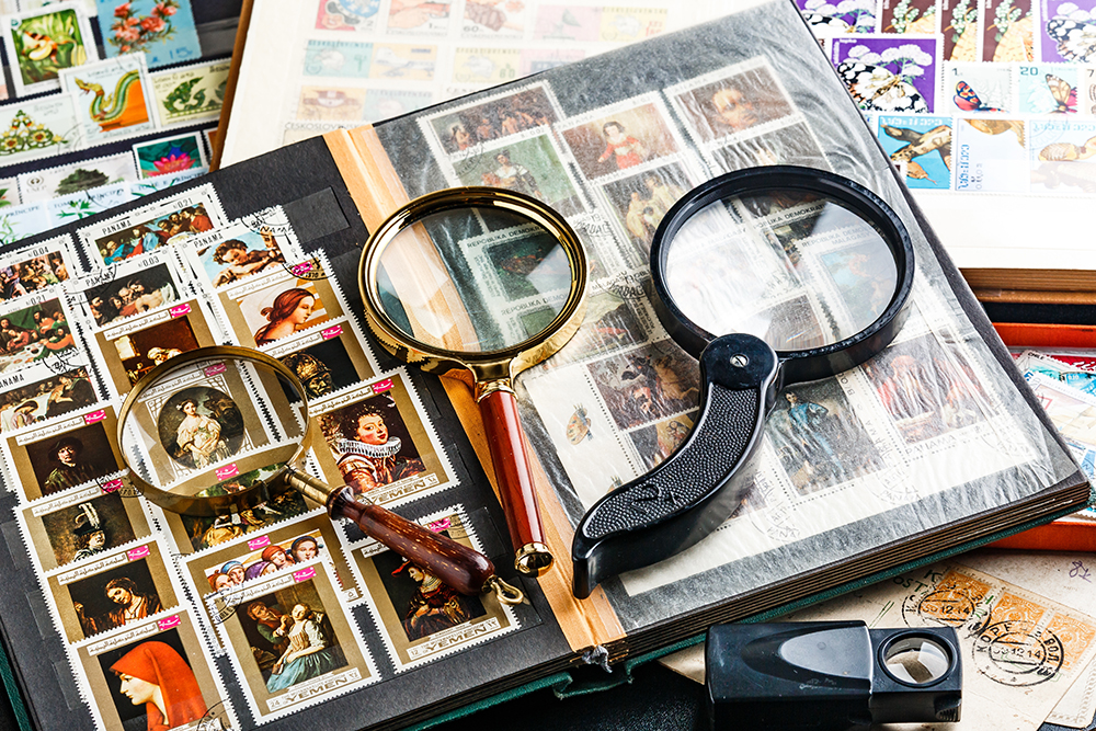 Postage stamps. Collection of stamps and magnifying glass. Collection of world stamps in a stack demonstrates the theme of art. Postage stamps of different countries and times