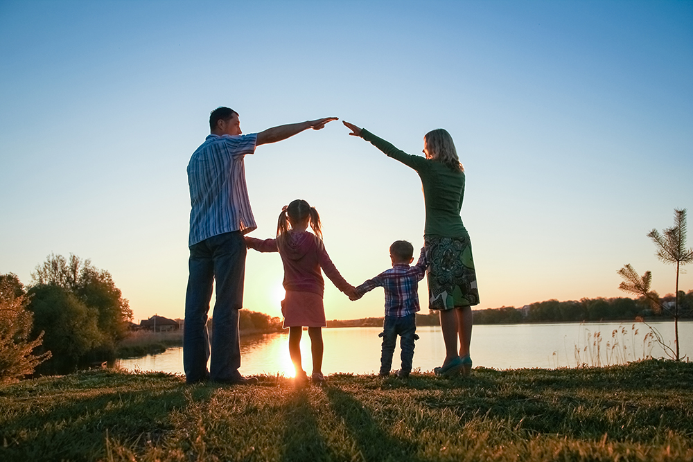 silhouette family, including his father, mother and two children in the hands of