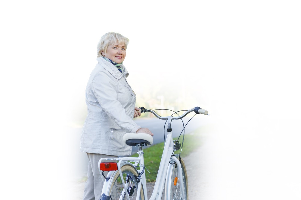 Active happy carefree smiling senior woman ridding bike in autumn nature.
