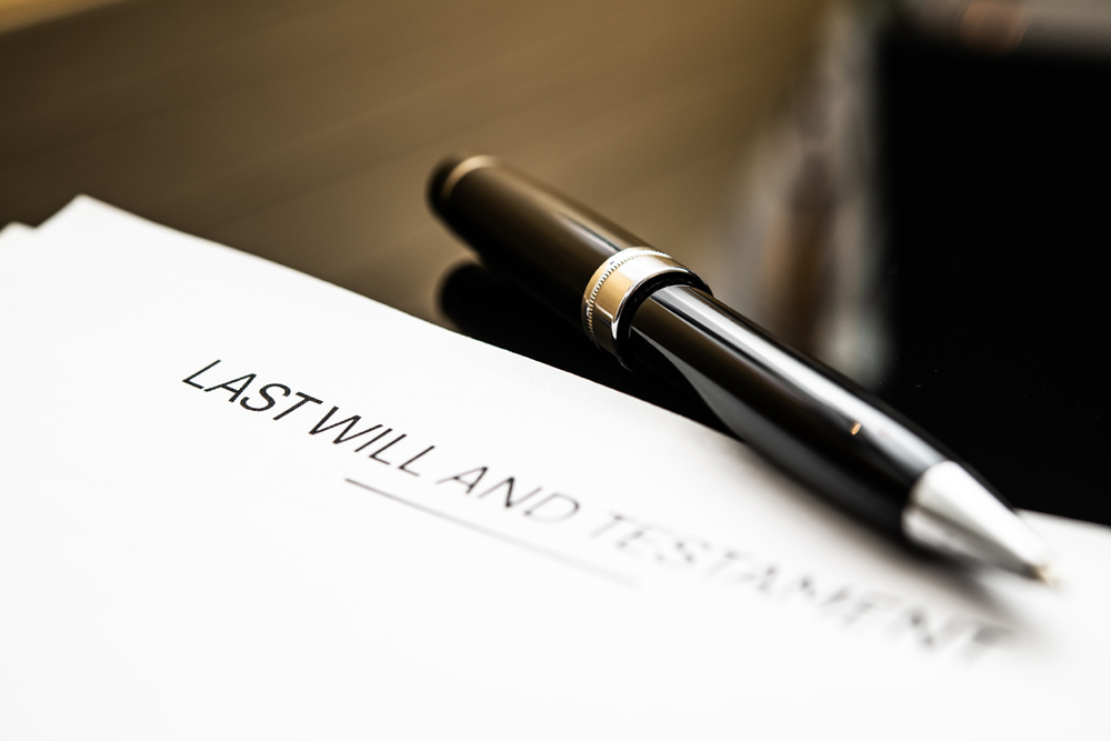 A close-up of a last will and testament document accompanied by a luxurious black pen, emphasizing the importance of legal documentation in estate planning and asset distribution.