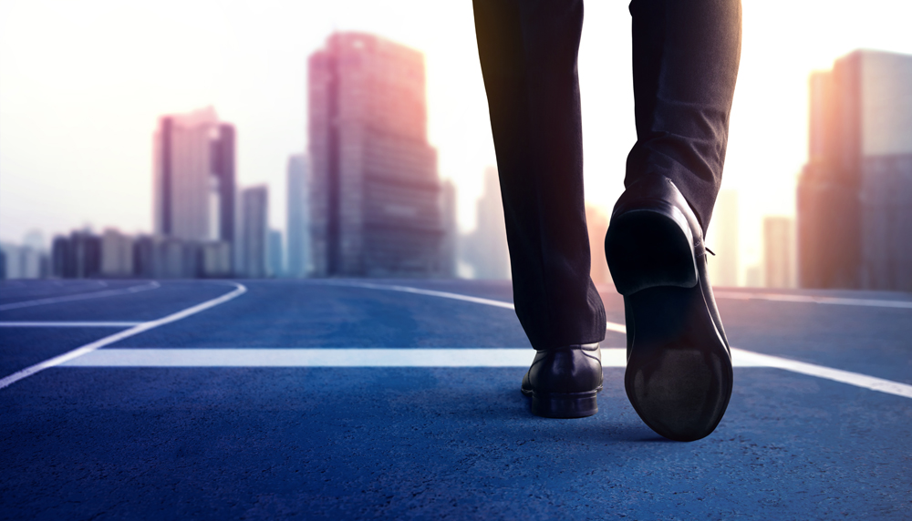 Start, Competition Concept. Low Section of Businessman Steps into Start Line on Running Track and Moving Forward to New Challenge. Blurred City Building as background