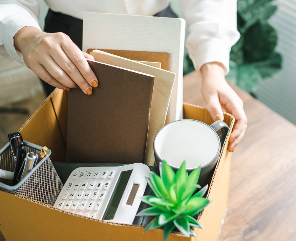 Business woman sending resignation letter and packing Stuff Resign Depress or carrying business cardboard box by desk in office. Change of job or fired from company.