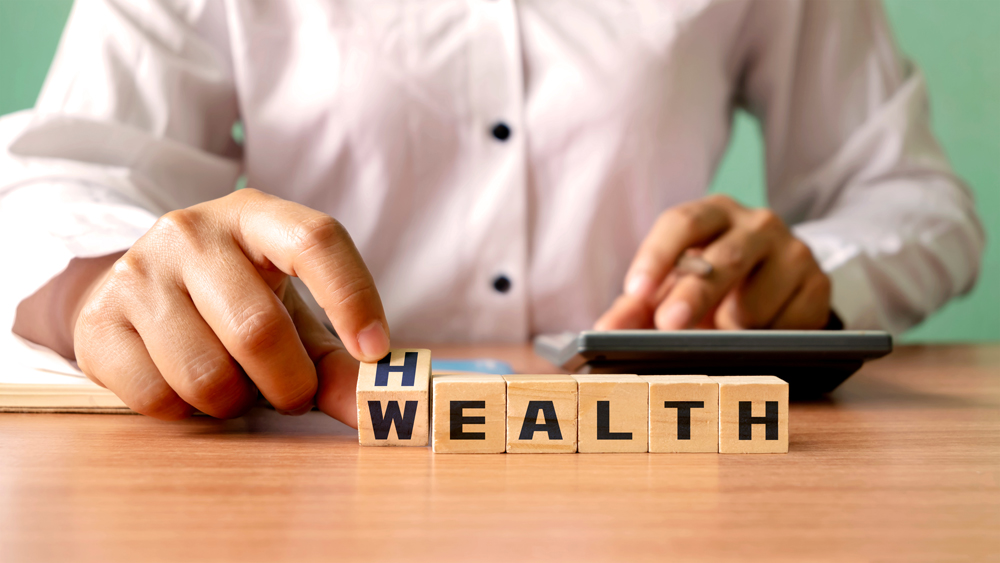 Young woman hand turning wooden dice with wealth and health, financial wealth concept. Investing in life and health insurance
