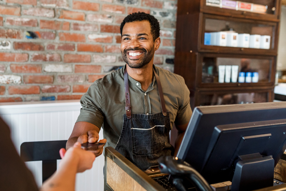 Receptionist taking payment for the customers. African American barber, black small business owner, African American business. Barbershop and happy barber.