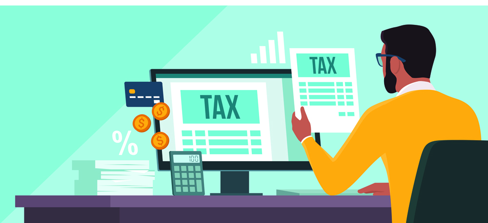 Online e-tax payment on computer: man checking tax forms on his computer and paying with a credit card