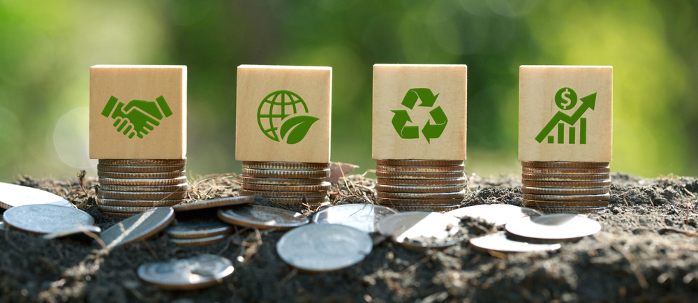 Green icons on wooden cubes on money coin stack. Green business growth. Finance sustainable development.growing money, finance and investment. Alternative sources of energy. Eco business investment