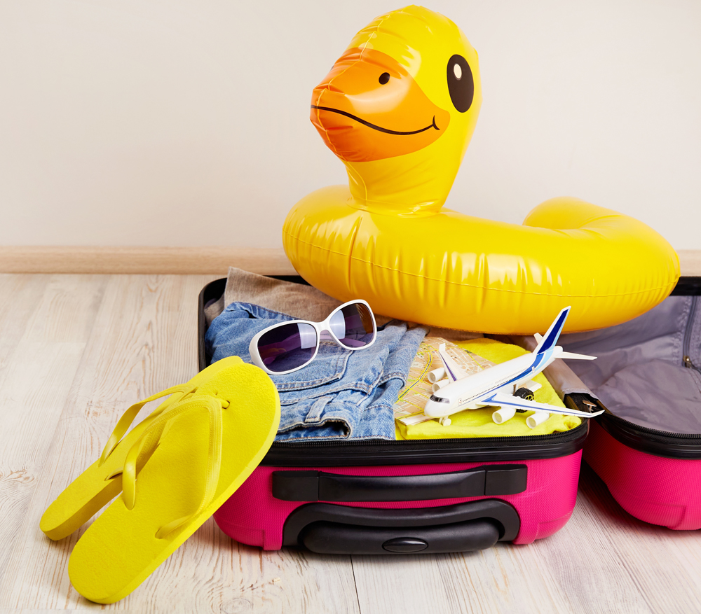 A suitcase with clothes and accessories for a seaside vacation. Summer travel, preparation for the trip.