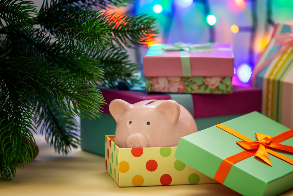 A small pink piggy bank in a festive box. Symbol of the New Year under the Christmas tree. Unusual gift.